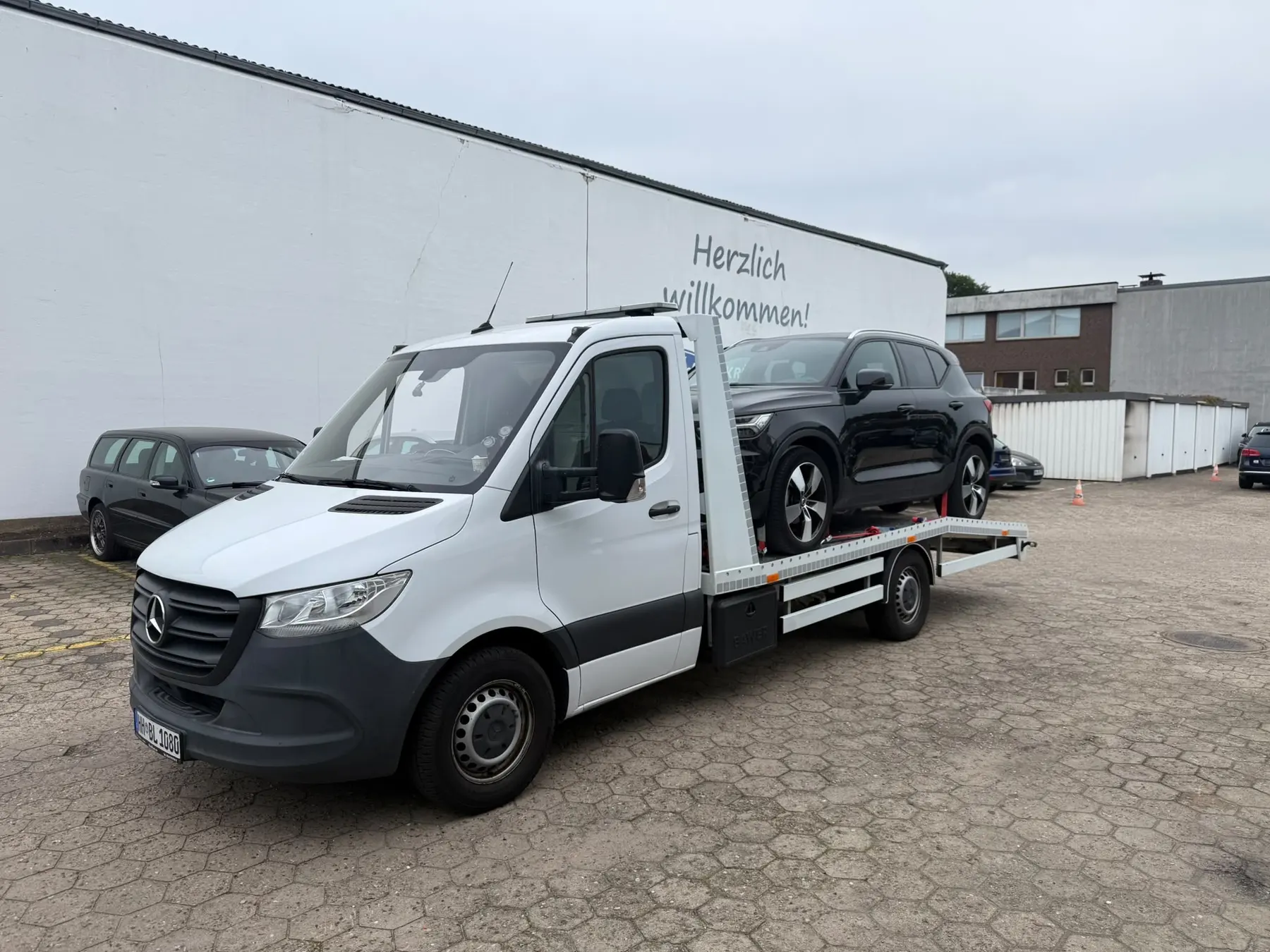 Schwarzer Volvo SUV auf dem BLITZ-Abschleppwagen auf einem Firmenhof